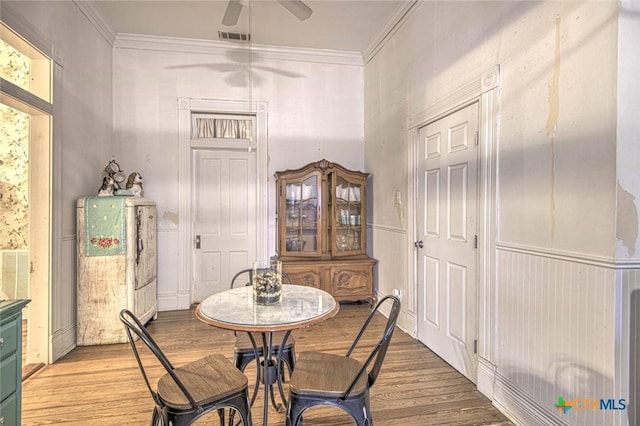 dining space featuring ceiling fan, ornamental molding, and light hardwood / wood-style flooring