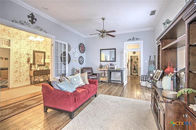 living room featuring light hardwood / wood-style flooring, ornamental molding, and ceiling fan