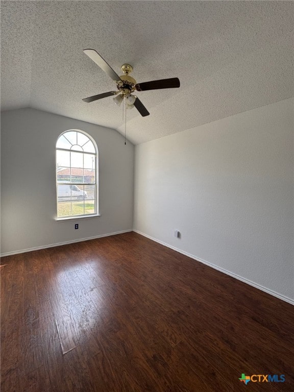 5105 Parkwood Dr, Killeen, TX 76542 - empty room with vaulted ceiling, ceiling fan, dark wood-style floors, and a textured ceiling