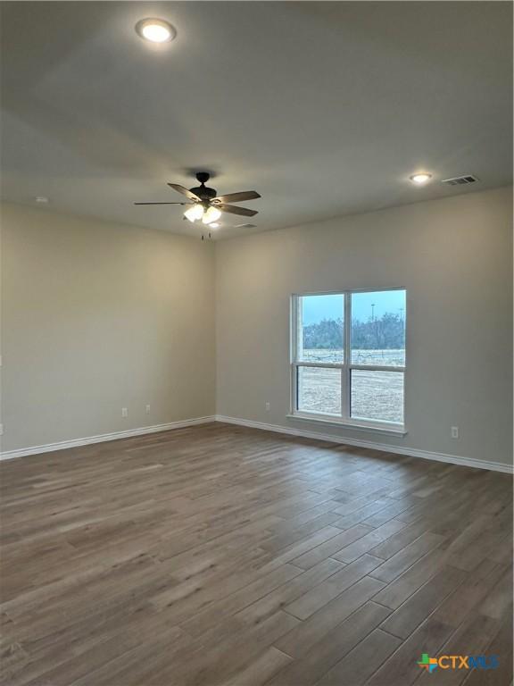 empty room with ceiling fan and light wood-type flooring