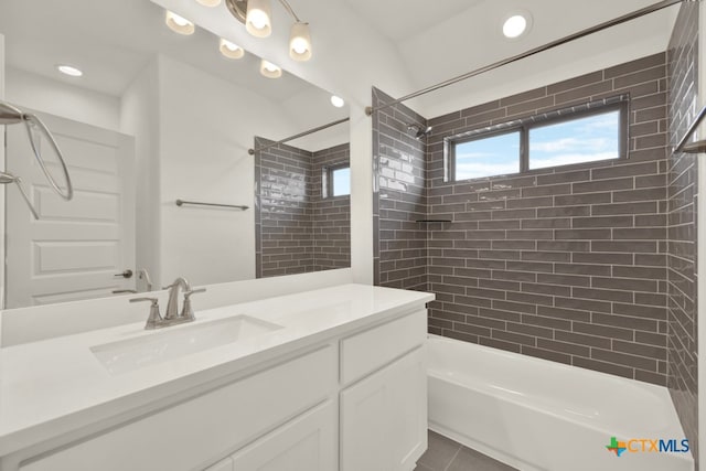 bathroom with tiled shower / bath combo, vanity, and tile patterned floors