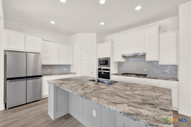 kitchen with light hardwood / wood-style flooring, white cabinetry, and stainless steel appliances