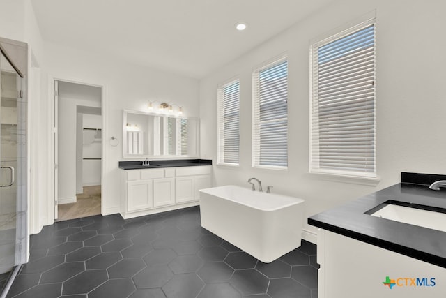 bathroom with tile patterned flooring, vanity, and plus walk in shower