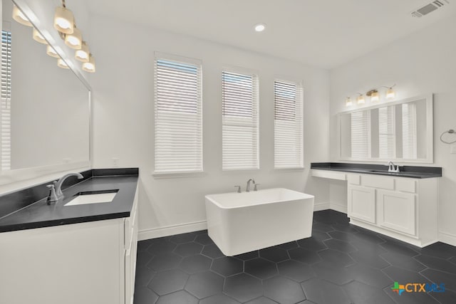 bathroom with vanity, tile patterned flooring, and a bathing tub