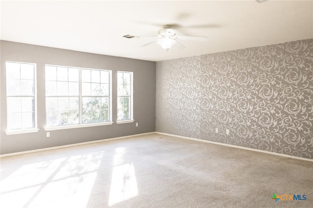 carpeted spare room with ceiling fan