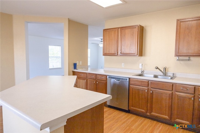 kitchen featuring a kitchen island, sink, dishwasher, ceiling fan, and light hardwood / wood-style flooring