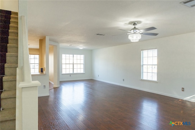 unfurnished living room featuring dark wood-type flooring and ceiling fan