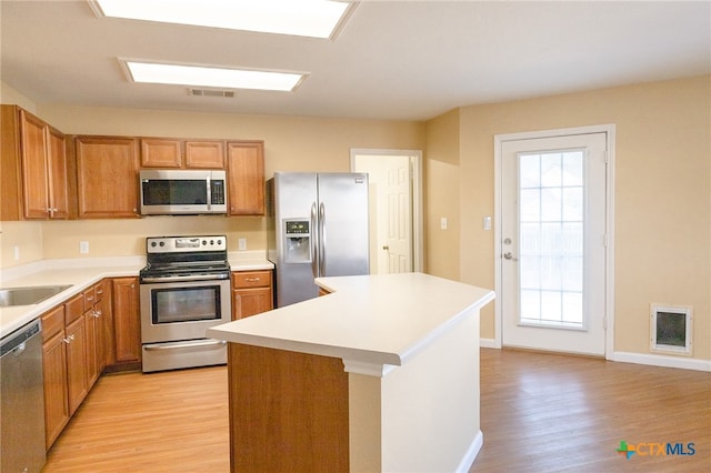 kitchen featuring light hardwood / wood-style floors, appliances with stainless steel finishes, and a center island