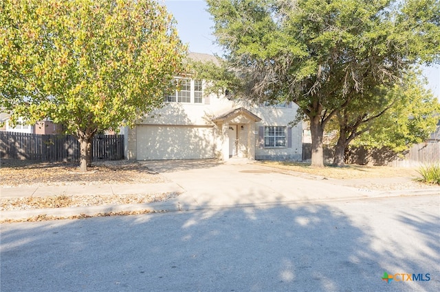 view of property hidden behind natural elements with a garage