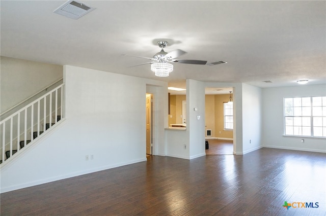 unfurnished living room featuring dark wood-type flooring and ceiling fan