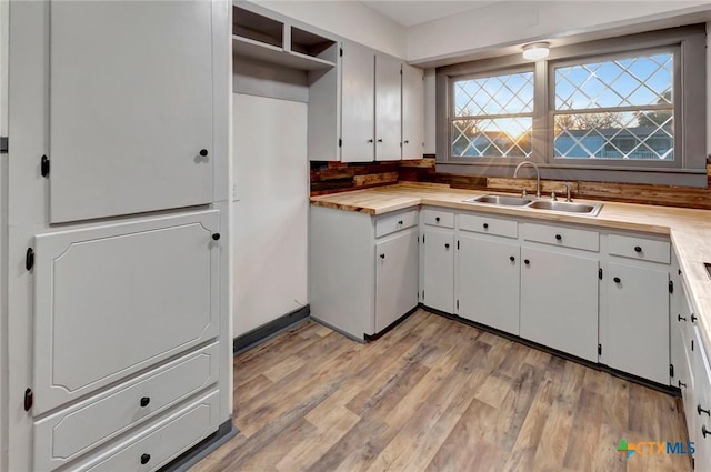 kitchen featuring white cabinetry, sink, and light hardwood / wood-style floors