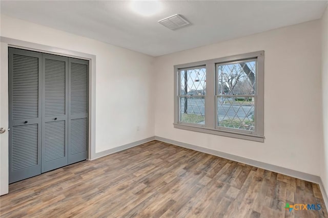 unfurnished bedroom with hardwood / wood-style flooring and a closet