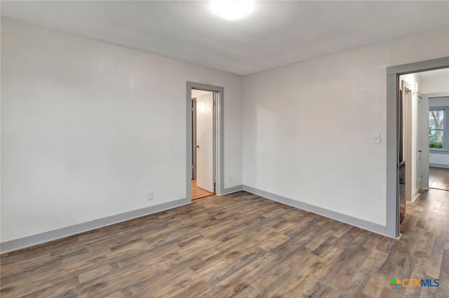 spare room with dark wood-type flooring