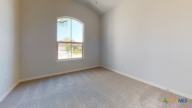 unfurnished room featuring carpet floors, baseboards, and vaulted ceiling