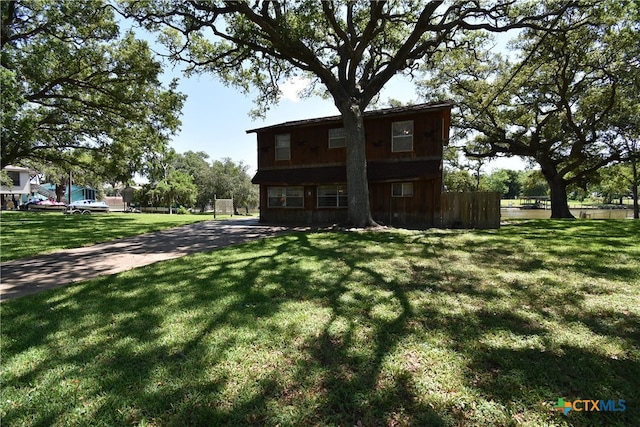 rear view of house featuring a yard