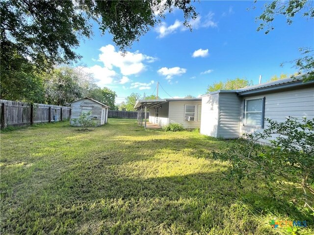 348 N Burke St, Goliad, TX 77963 - view of yard featuring a fenced backyard, a storage unit, and an outdoor structure