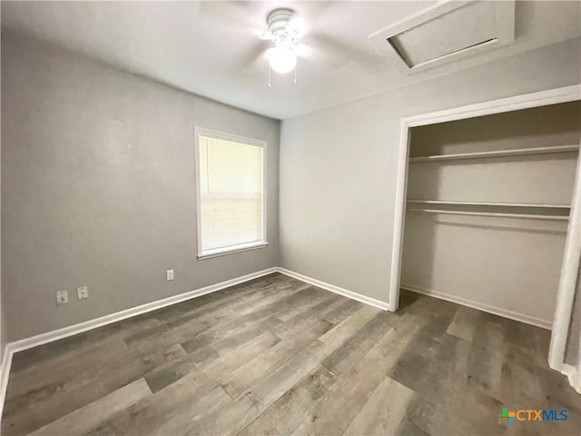 348 N Burke St, Goliad, TX 77963 - unfurnished bedroom with ceiling fan, attic access, baseboards, wood finished floors, and a closet