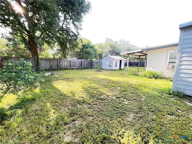 348 N Burke St, Goliad, TX 77963 - view of yard featuring a storage shed, a fenced backyard, and an outbuilding