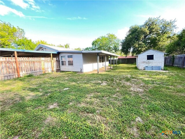 348 N Burke St, Goliad, TX 77963 - view of yard with a fenced backyard, an outdoor structure, and a shed