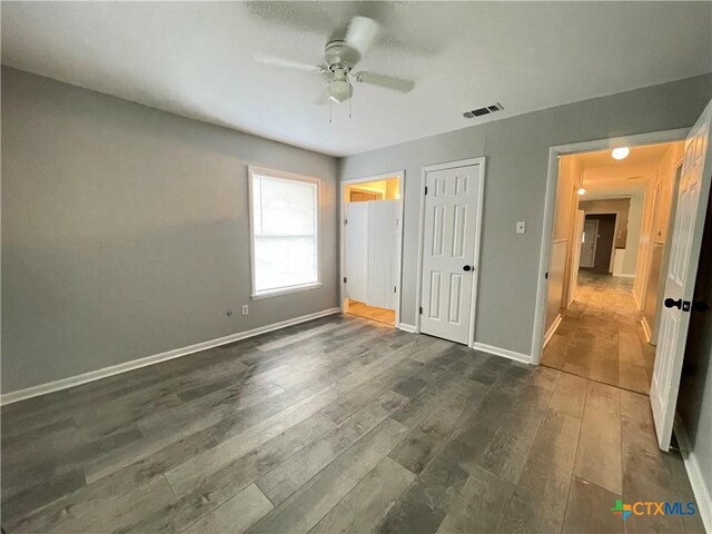 348 N Burke St, Goliad, TX 77963 - unfurnished bedroom featuring visible vents, dark wood-style flooring, ceiling fan, and baseboards