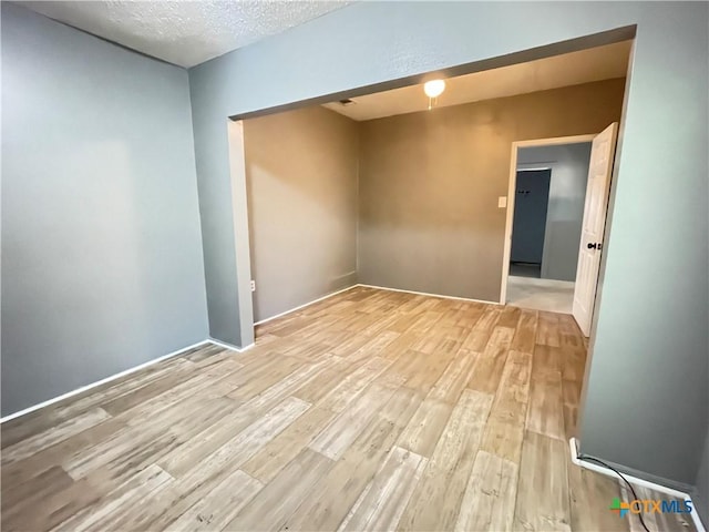 348 N Burke St, Goliad, TX 77963 - unfurnished room featuring light wood-type flooring and a textured ceiling