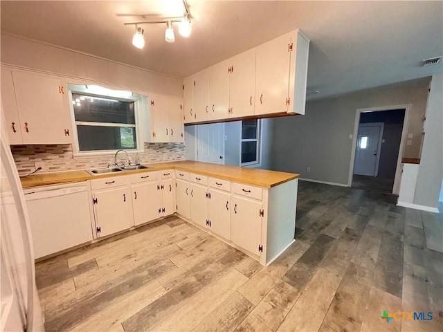 348 N Burke St, Goliad, TX 77963 - kitchen with white dishwasher, light wood-type flooring, light countertops, a sink, and backsplash