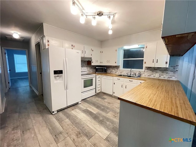 348 N Burke St, Goliad, TX 77963 - kitchen with white appliances, under cabinet range hood, a sink, and light wood-style floors