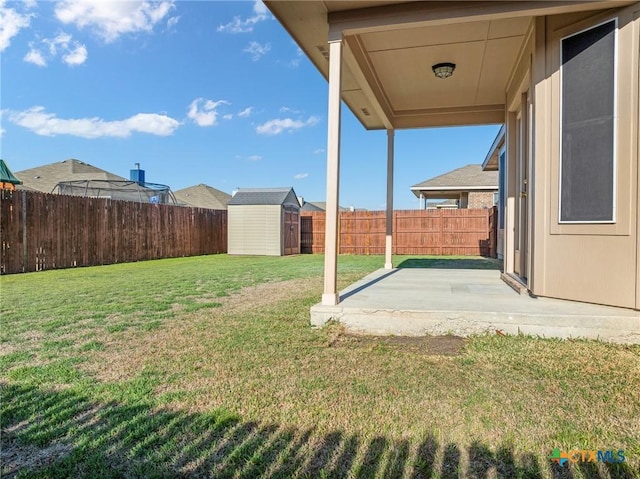 view of yard featuring an outbuilding, a storage unit, a fenced backyard, and a patio area