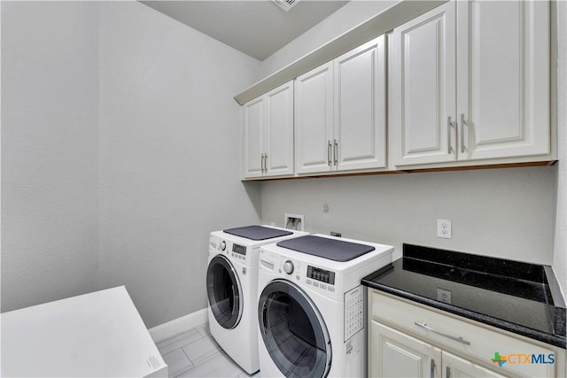 laundry room with cabinets, washing machine and dryer, and light tile patterned flooring