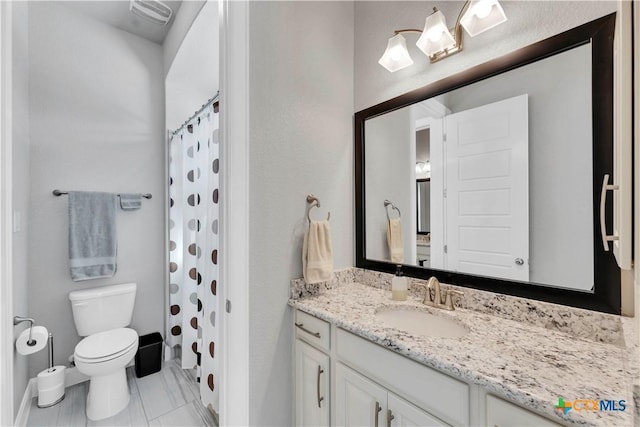 bathroom featuring a shower with curtain, vanity, toilet, and tile patterned floors