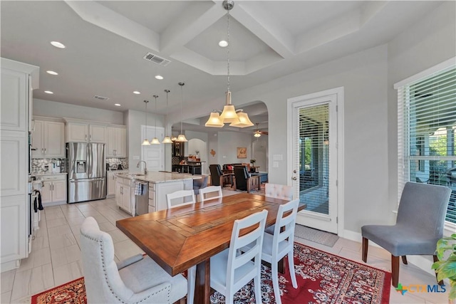 dining area featuring beamed ceiling, light tile patterned floors, sink, and coffered ceiling