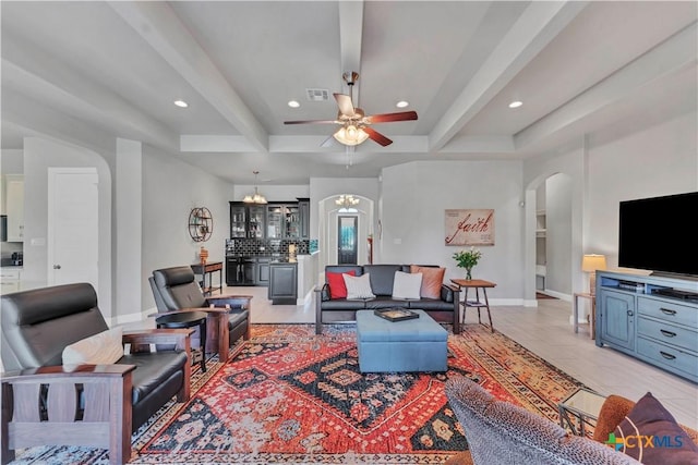 tiled living room with ceiling fan with notable chandelier