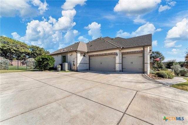 view of front of property featuring central AC and a garage