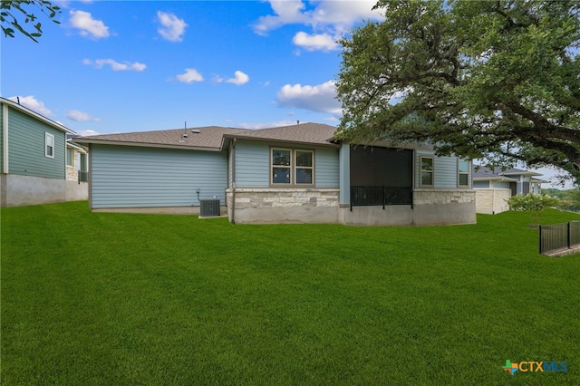 rear view of house with cooling unit and a yard