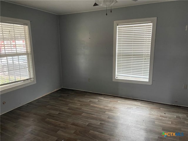 empty room with ceiling fan and dark wood-type flooring