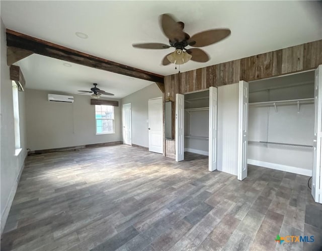 unfurnished living room featuring a wall unit AC, ceiling fan, and dark wood-type flooring