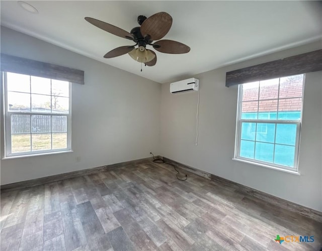 empty room with a wall unit AC, ceiling fan, and hardwood / wood-style floors