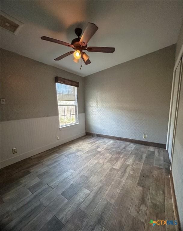 3101 Bobolink Ln, Victoria, TX 77901 - empty room featuring wood finished floors, ceiling fan, and a wainscoted wall