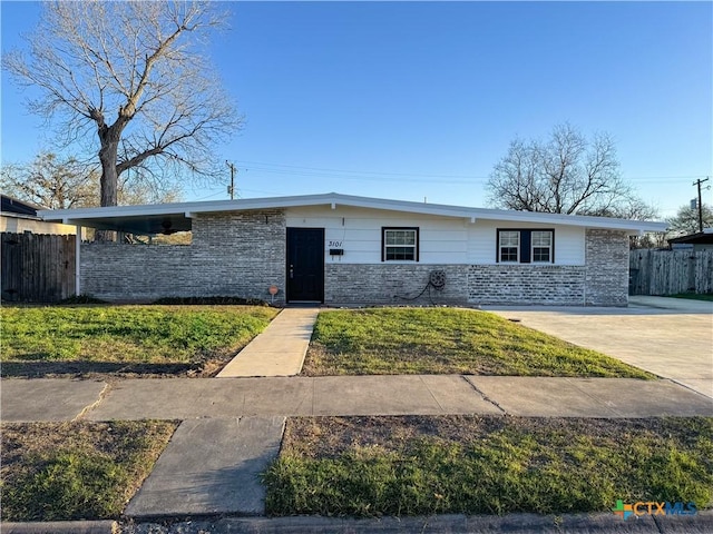 view of front of home featuring fence, driveway, and a front lawn