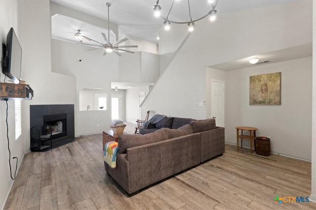 4203 Rambling Range Dr, Killeen, TX 76549 - living area with wood finished floors, a towering ceiling, a ceiling fan, stairs, and a tiled fireplace