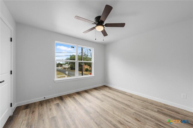 spare room with light wood-type flooring and ceiling fan