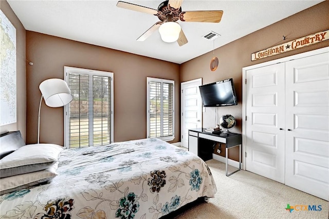 carpeted bedroom with visible vents and a ceiling fan