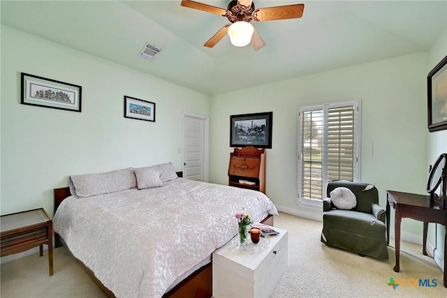 bedroom featuring visible vents, baseboards, a tray ceiling, carpet flooring, and a ceiling fan