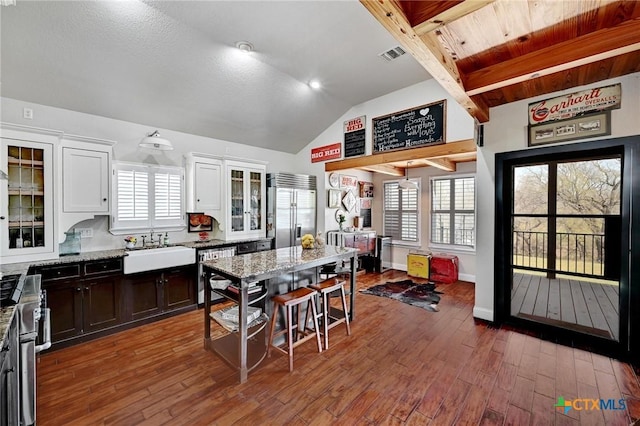 kitchen featuring visible vents, a sink, stainless steel appliances, white cabinets, and dark wood-style flooring