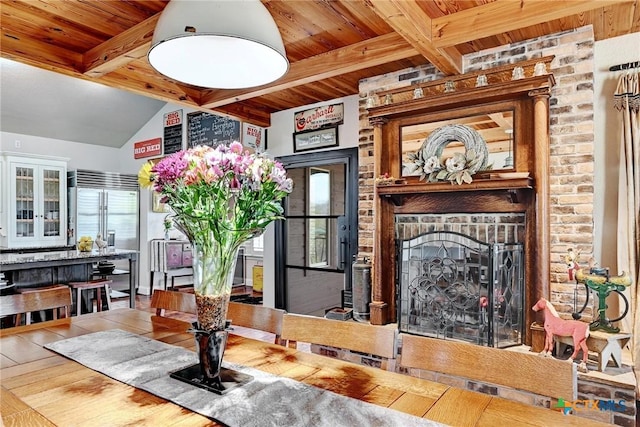 dining area featuring wood finished floors, vaulted ceiling with beams, and wood ceiling