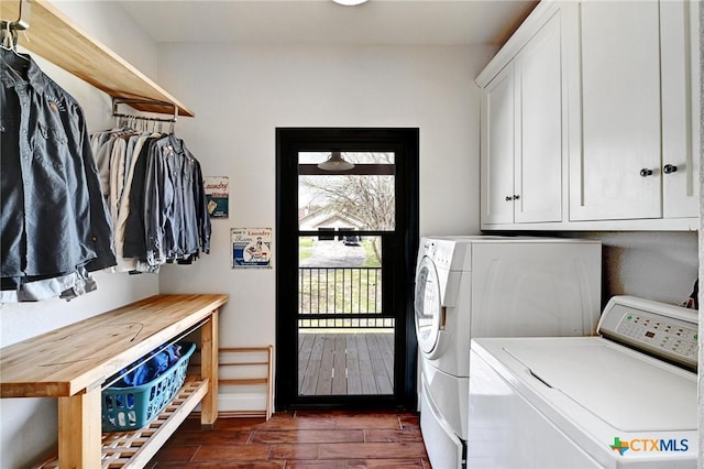 laundry area featuring washing machine and clothes dryer, cabinet space, baseboards, and dark wood-style flooring