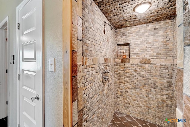 full bathroom featuring brick ceiling and tiled shower