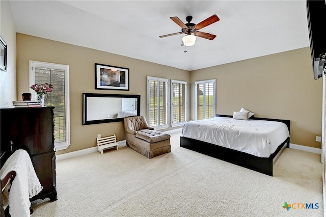 carpeted bedroom featuring baseboards and ceiling fan