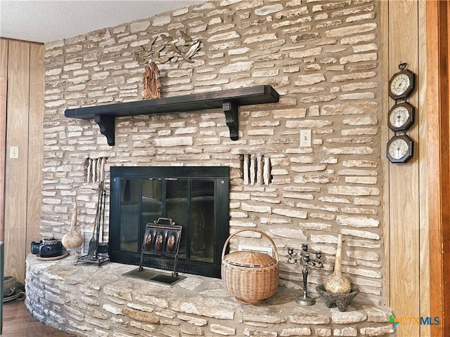 interior details featuring a textured ceiling and a stone fireplace