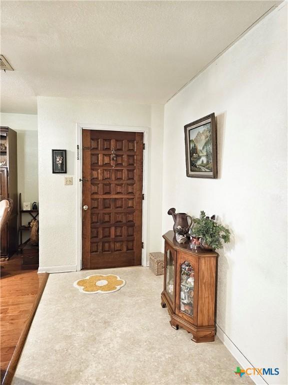 foyer featuring hardwood / wood-style floors and a textured ceiling